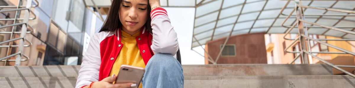 stressed person sitting on a stairway on their phone