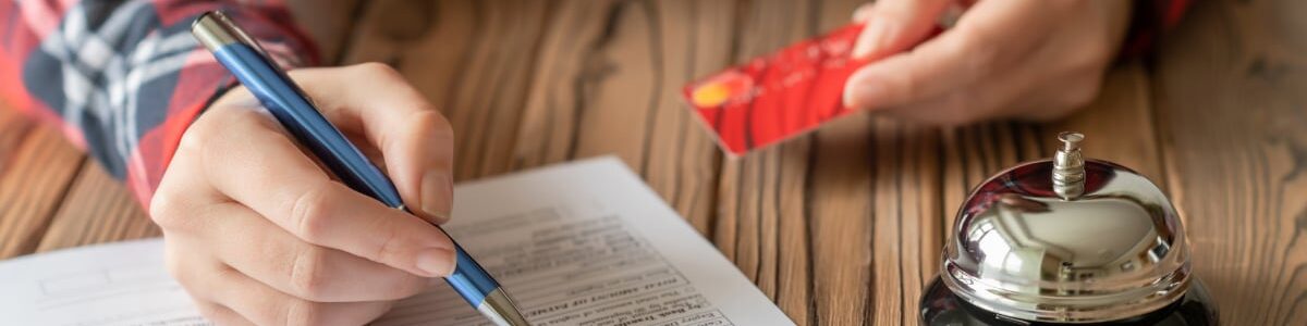 someone signing a contract with a bell beside the contract