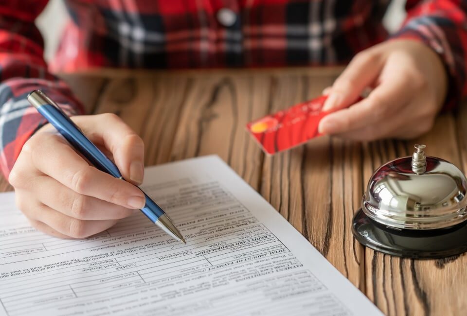 someone signing a contract with a bell beside the contract