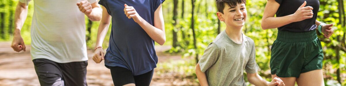 family of 4 jogging in the woods