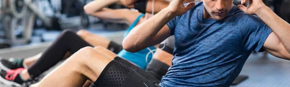 man exercising in a gym with company