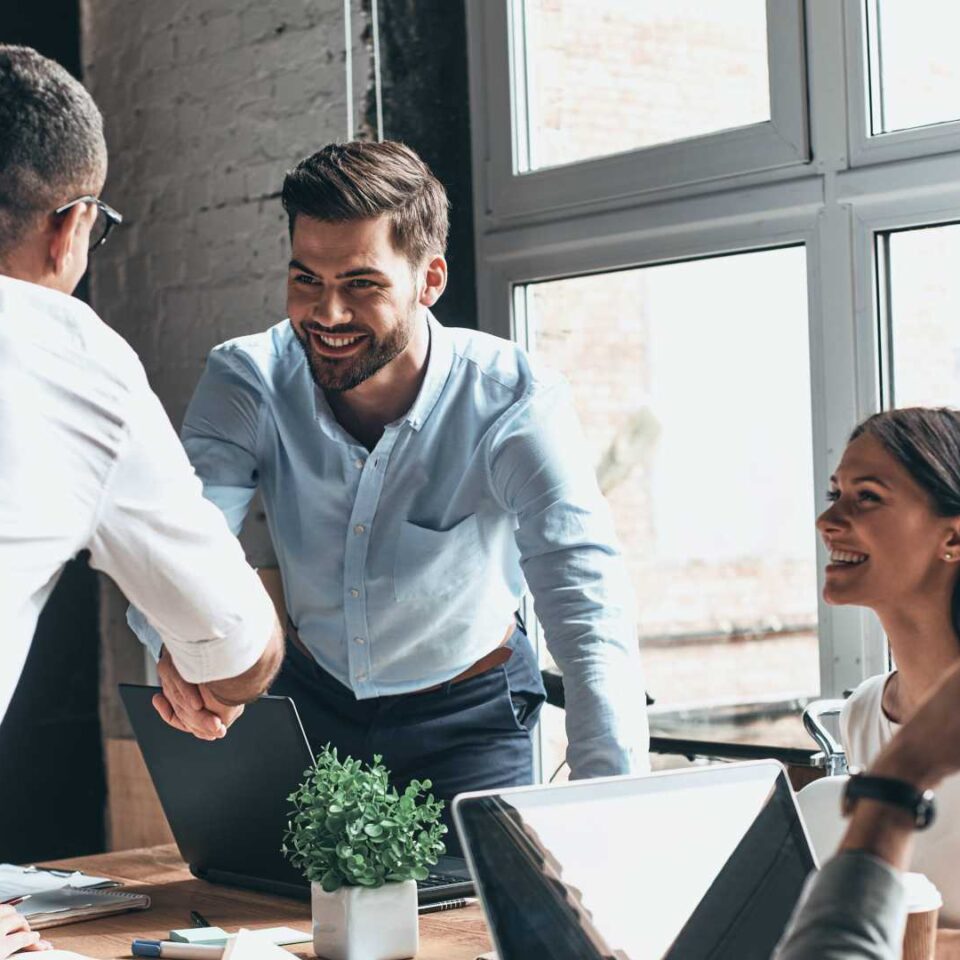 two male workers agreeing with a hand shake